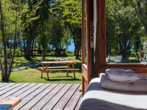 a porch of a cabin with a picnic table in the yard at La Huala in San Carlos de Bariloche
