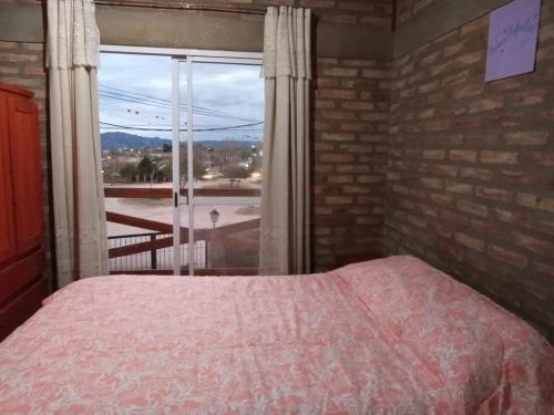 a bedroom with a bed and a large window at CABAÑAS DE MORA in Villa Santa Cruz del Lago