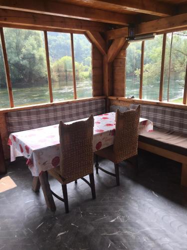 a dining room with a table and chairs in a cabin at Vikendica Na Plivi in Šipovo