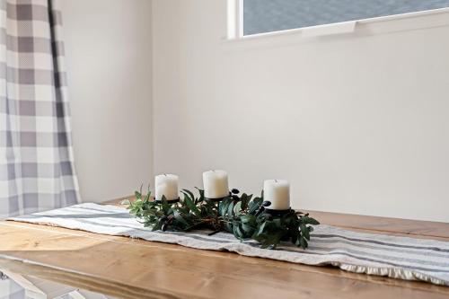 a table with candles and plants on top of a table at Modern Cabin Vibes, Vaulted ceilings, Sleeps 8! in Caldwell