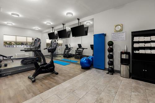 a gym with treadmills and exercise equipment in a room at Clarion Pointe Hinesville near Fort Stewart in Hinesville