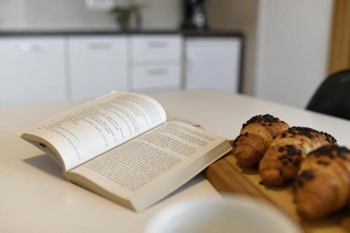 een open boek zittend op een tafel met brood bij Apart Residence Rudan 1 in Rovinj