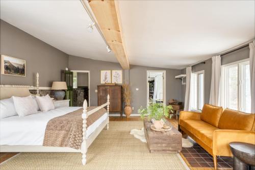 ein Schlafzimmer mit einem Bett und einem Sofa in der Unterkunft River Lodge by AvantStay 11 BR Historic Estate w Pool Views of Hudson in Hudson