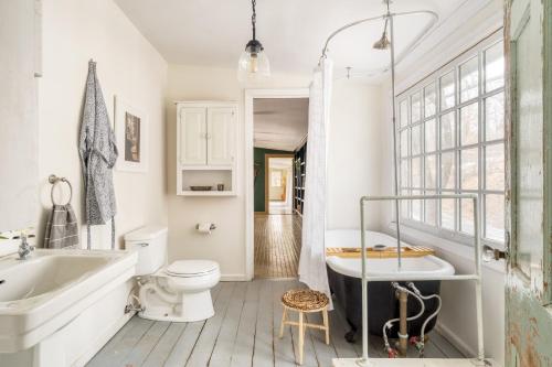 uma casa de banho com uma banheira, um WC e um lavatório. em River Lodge by AvantStay 11 BR Historic Estate w Pool Views of Hudson em Hudson