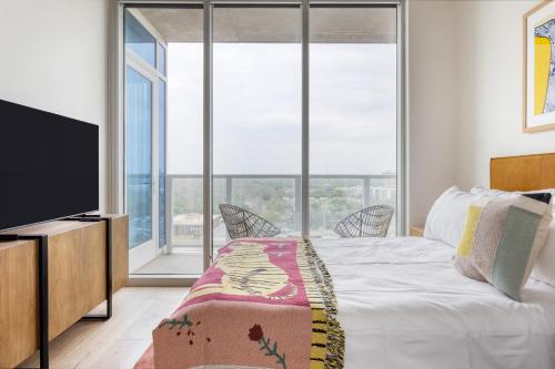 a bedroom with a bed and a flat screen tv at Billy by AvantStay Brand New Condo in Austin w Amazing Amenities in Austin