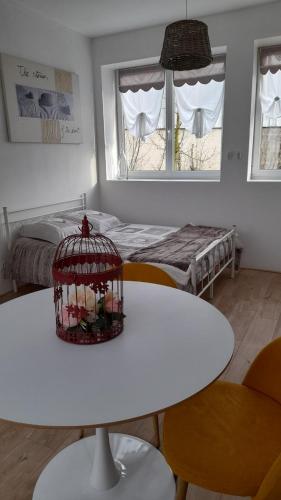 a room with a white table and a bird cage at Gîte location meublée Aumale - studio en centre-ville - La maison en brique in Aumale