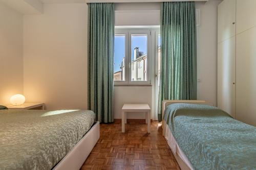 Habitación de hotel con 2 camas y ventana en Oleaclub Locazione Turistica, en Asolo