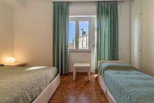 a hotel room with two beds and a window at Oleaclub Locazione Turistica in Asolo