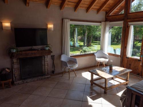 uma sala de estar com lareira e uma televisão de ecrã plano em La Huala em San Carlos de Bariloche