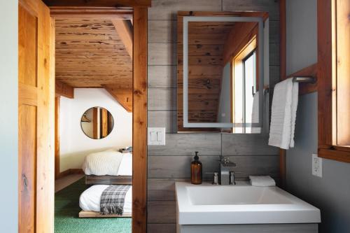 La salle de bains est pourvue d'un lavabo et d'un miroir. dans l'établissement Timberline by AvantStay Stunning Chalet Cabin w Hot Tub Pool Table Home Theater, à Tahoe Vista