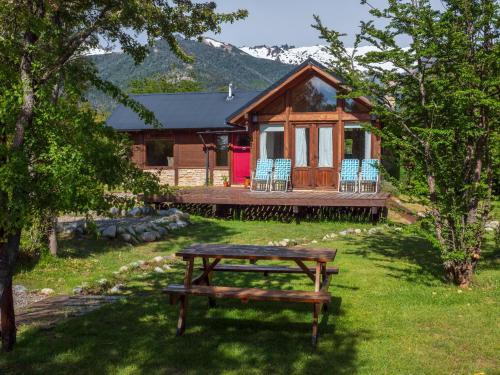 a log cabin with a picnic table in front of it at La Huala in San Carlos de Bariloche
