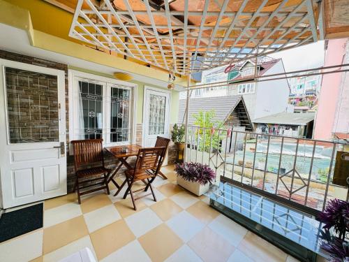 a room with a table and chairs and a balcony at Home Thỏ Vân Anh in Da Lat