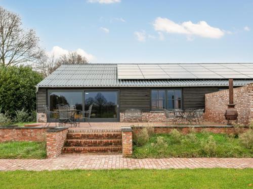 a house with a solar roof and a patio at De Hoeve II in Hulsel