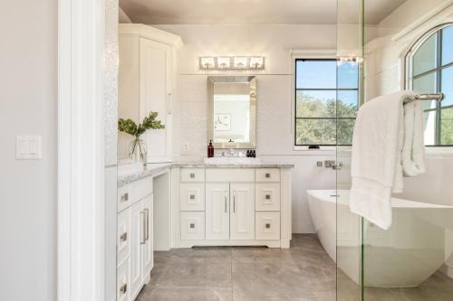 a white bathroom with a tub and a sink at Sea Crown by AvantStay 5mins from the Beach w Multiple Terraces PermitSLP13639 in Newport Beach