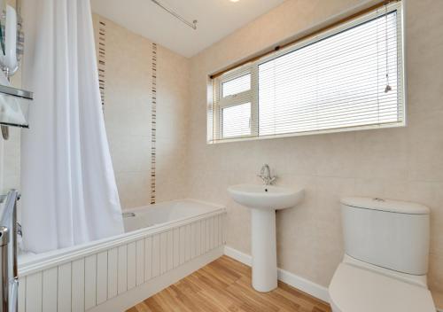 a bathroom with a sink and a tub and a toilet at Primley Park in Paignton