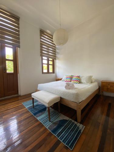 a bedroom with a bed and a bench and windows at Castelletto Bed & Breakfast in Santiago