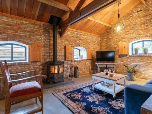 a living room with a fireplace and a brick wall at De Hoeve I in Hulsel