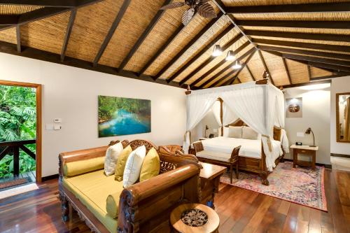a living room with a bed and a couch at Hideaway Rio Celeste Hotel in Bijagua
