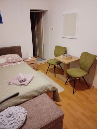 a room with two beds and a table and chairs at Studio Apartman Ivanka in Orebić