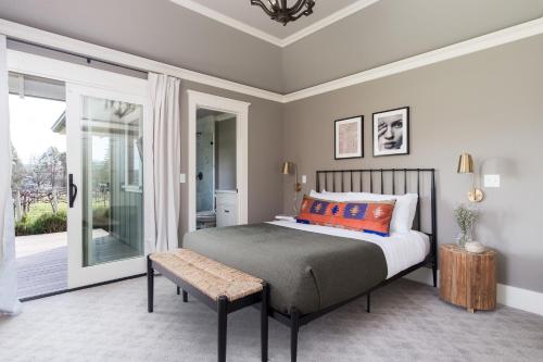 1 dormitorio con cama con banco y ventana en Wellington by AvantStay Secluded Wine Country Estate w Gorgeous Mtn Views, en Kenwood