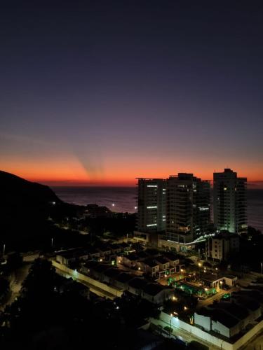 a city skyline at night with a rainbow in the sky at El Samario Cumbia Host-Playa Salguero- Santa Marta in Gaira