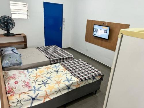 a bedroom with two beds and a blue door at Studio proximo Expo Center Norte bairro Vila Guilherme São Paulo in São Paulo