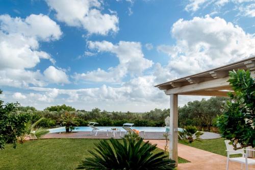 a backyard with a pool and a pergola at Villa Selinus in Castelvetrano Selinunte