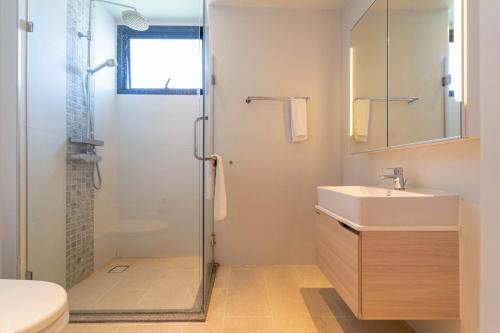 a bathroom with a glass shower and a sink at Diamond Resort in Phuket Town
