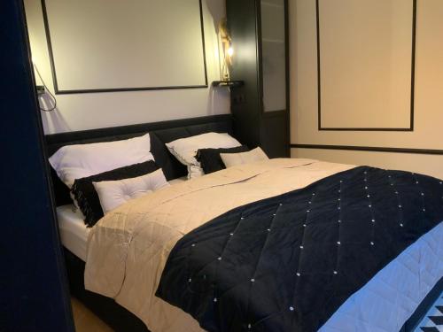 1 dormitorio con 1 cama con almohadas blancas y negras en Midcoast Wohnung „THE BLACK“, en Nortorf