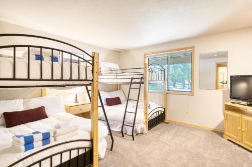 1 Schlafzimmer mit 2 Etagenbetten und einem TV in der Unterkunft Tanner by AvantStay Modern Cascades Escape in Brothers