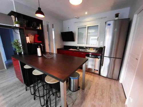 une cuisine avec une table en bois et un réfrigérateur dans l'établissement Maison climatisée confortable, à Trèbes