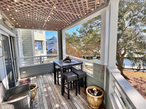 a screened in porch with a table and chairs at Just Another Day in Paradise in Manteo