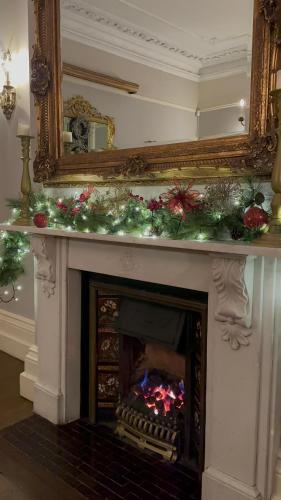 a fireplace with christmas decorations on top of it at The Old Manor House Hotel in Keynsham