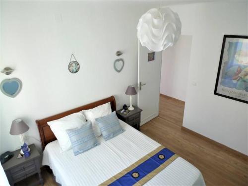 une chambre avec un lit avec des oreillers bleus et blancs dans l'établissement Maison 4 pers avec jardin au pied des montagnes, à Ria