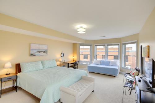 a bedroom with a large bed and a blue couch at Phoenix Nest South Haven Condo River View! in South Haven