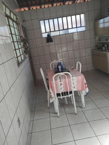 - une cuisine avec une table et des chaises dans la chambre dans l'établissement Casa férias Cátia, à Contagem