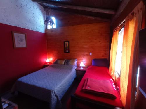 2 camas en una habitación pequeña con luces rojas en Titernig del Monte en Capilla del Monte