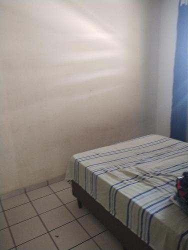 uma cama num quarto com um colchão listrado em Casa férias Cátia em Contagem