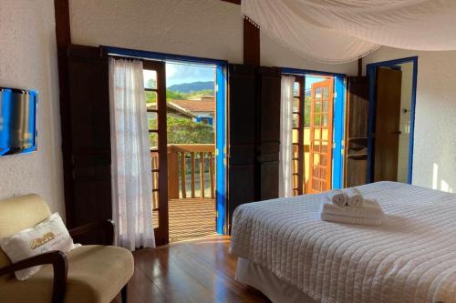 a bedroom with a bed and a view of a balcony at Pousada Vivenda in Tiradentes