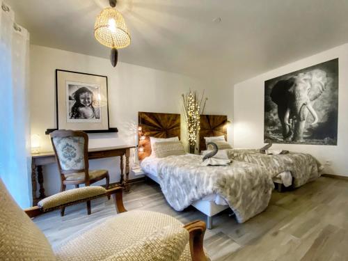 1 Schlafzimmer mit 2 Betten und einem Schreibtisch in der Unterkunft L'OSMOSE avec balcon, 3mn place centrale Château in Saverne