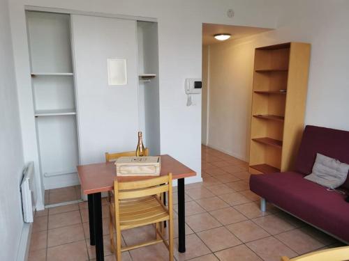 a room with a table and chairs and a couch at Superbe Studio de 23m² in Nîmes