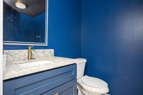 a blue bathroom with a toilet and a sink at Luxurious Extended Stay Dream~3 Kings~Desks~TV's in Snellville