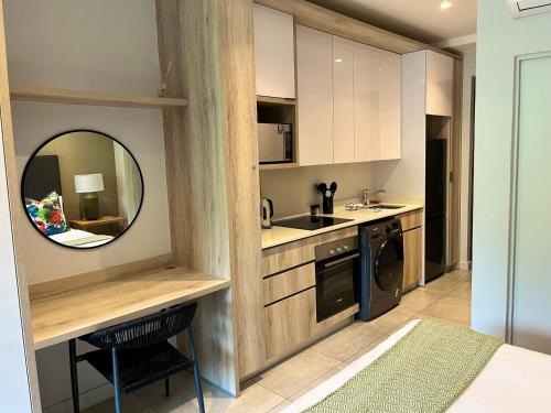 a kitchen with white cabinets and a mirror and a sink at Zimbali Boulevard Suites 159 in Ballito