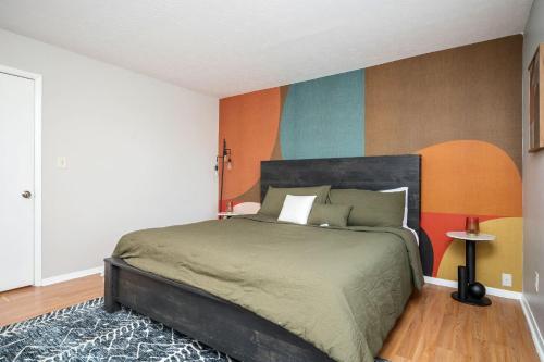 a bedroom with a bed and a colorful wall at Luxurious Extended Stay Dream~3 Kings~Desks~TV's in Snellville