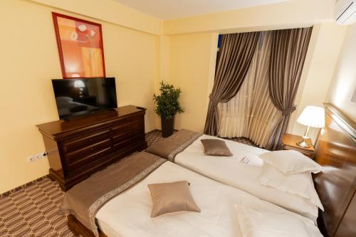 a hotel room with two beds and a television at Hotel Dorna in Vatra Dornei
