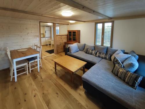 ein Wohnzimmer mit einem Sofa und einem Tisch in der Unterkunft Sunny Garden - Charmantes Chalet mit Aussicht in Aeschi bei Spiez