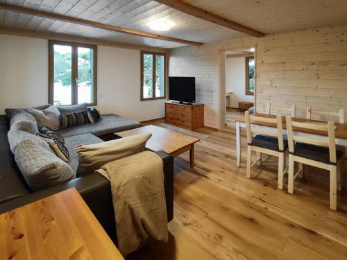 ein Wohnzimmer mit einem Sofa und einem Tisch in der Unterkunft Sunny Garden - Charmantes Chalet mit Aussicht in Aeschi bei Spiez