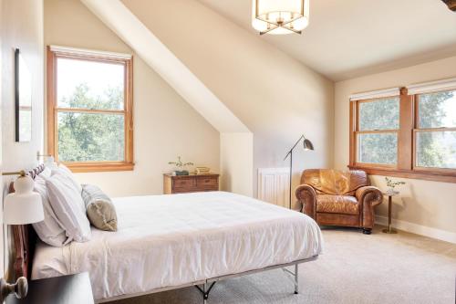 1 dormitorio con 1 cama, 1 silla y ventanas en Dolcetto by AvantStay Wine Country Mansion Minutes from Vineyards en Paso Robles