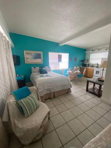 a bedroom with a bed and a chair at Private Studio 15 -Directly Across from Beach in St Pete Beach