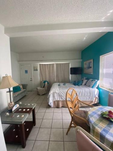 a bedroom with a bed and a table and a couch at Private Studio 15 -Directly Across from Beach in St Pete Beach